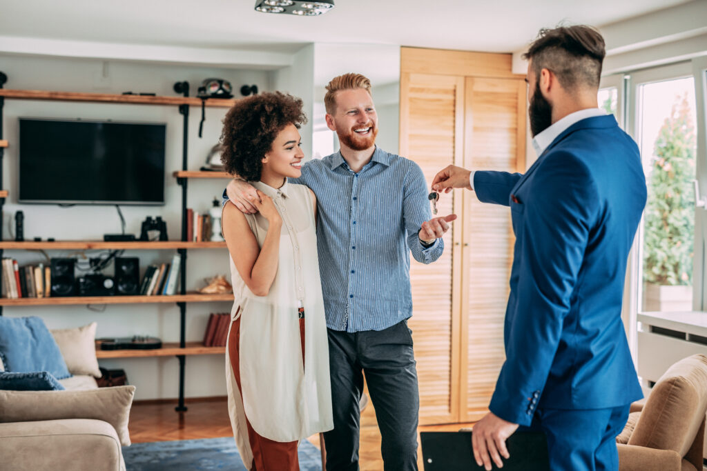 Realtor handing couple keys to home